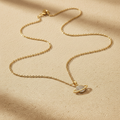 Gouden planeet ketting op beige achtergrond